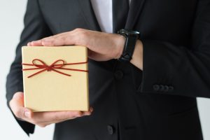 Cadeaux d'entreprise personnalisés en Tunisie pour 2024 : homme présentant un coffret cadeau