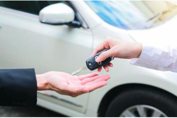 Un vendeur transmettant la clé de sa voiture d'occasion à son acheteur en Tunisie