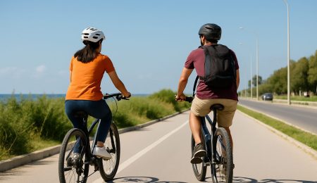 Couple tunisien en balade à vélo sur une piste cyclable au bord de mer — mobilité douce et liberté d’été en Tunisie