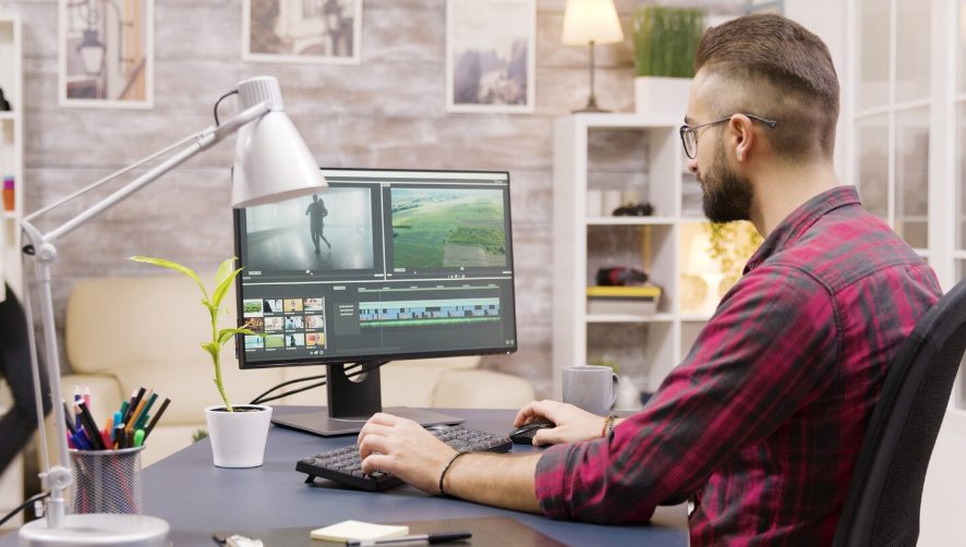Créateur vidéo utilisant un logiciel de montage professionnel depuis son bureau à domicile.
