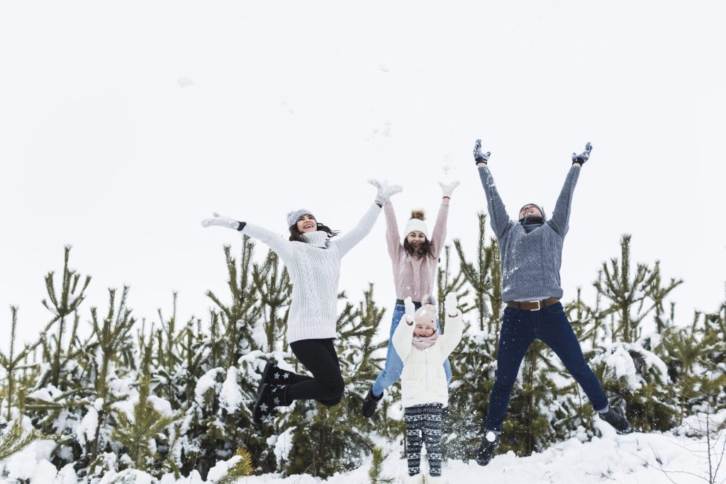 Famille sautant joyeusement dans la neige à Tabarka