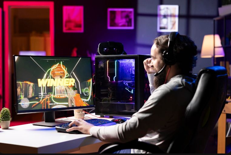 Joueur sur PC célébrant sa victoire lors d’une partie de jeu vidéo.