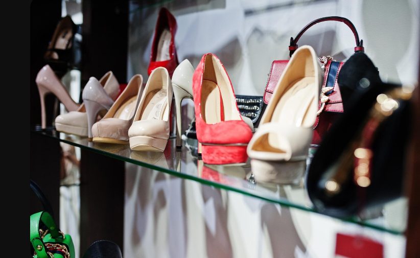 Collection de chaussures et talons exposés sur étagères en verre