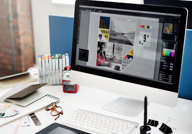 Poste de travail de designer graphique avec création visuelle sur écran et outils de design