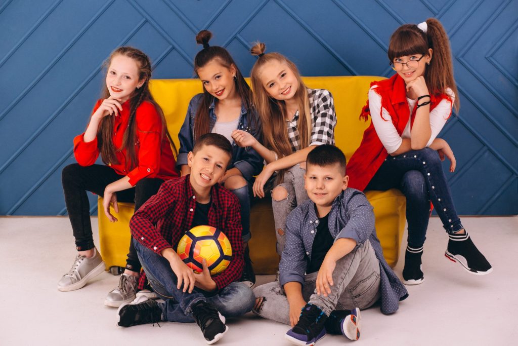 enfants souriants assis sur un canapé coloré