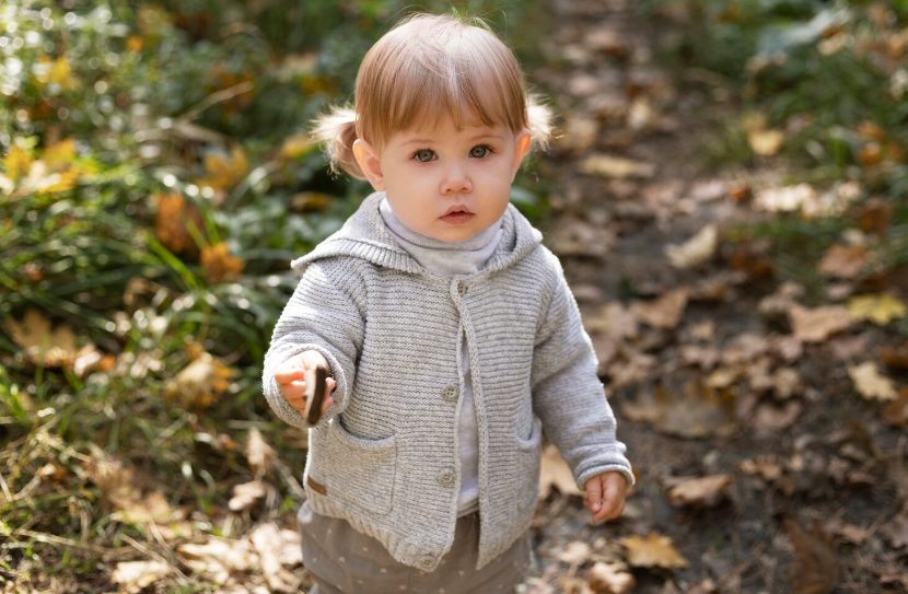 bébé avec gilet tricoté gris beige et col roulé blanc tenue enfant confortable