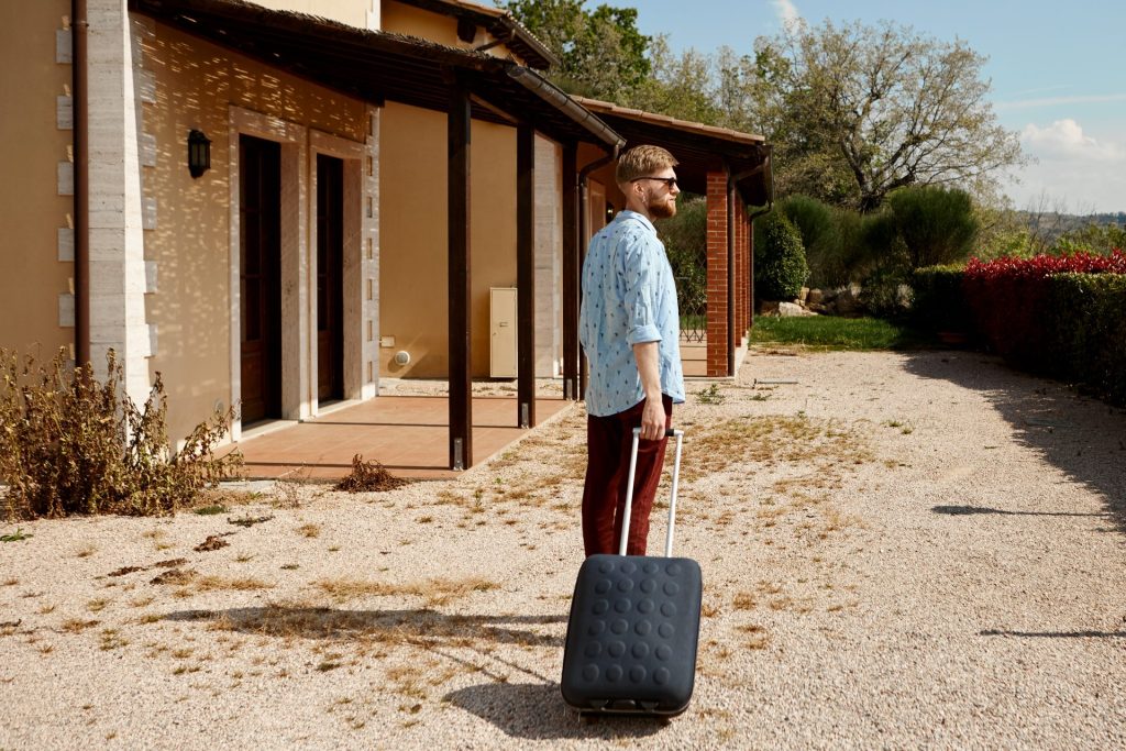 voyageur avec valise arrivant dans une maison de vacances