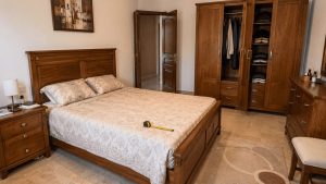 Chambre à coucher d’occasion en bois avec lit double, armoire ouverte et commode en Tunisie