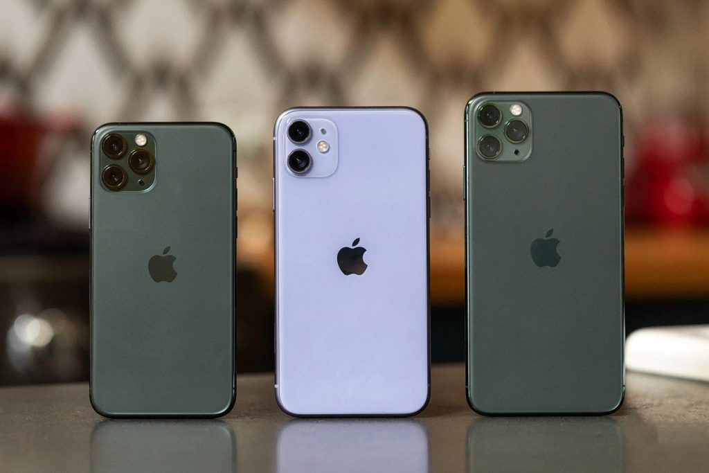 Trois modèles iPhone 11 d'occasion posés côte à côte : iPhone 11 violet, 11 Pro et 11 Pro Max vert nuit