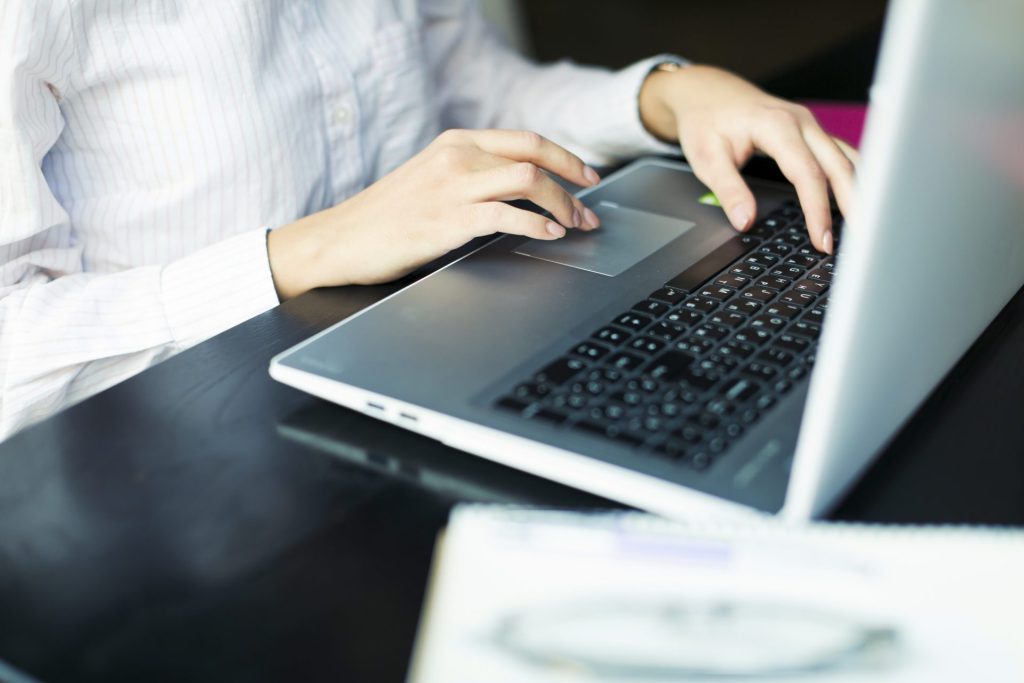 Mains posées sur le clavier rétroéclairé d'un ordinateur portable professionnel