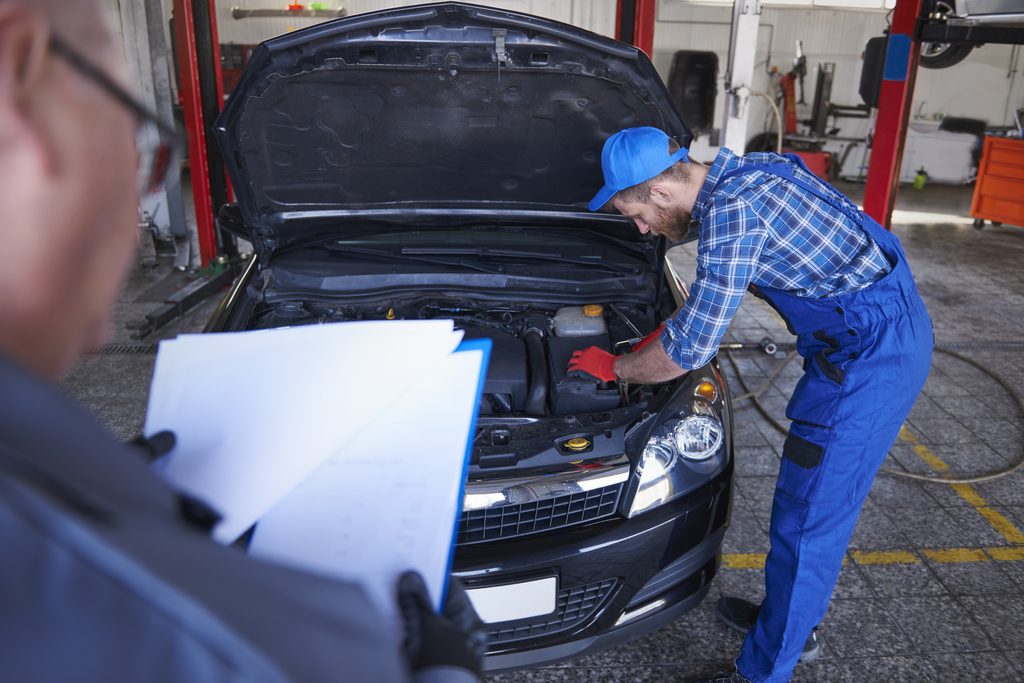 Un mécanicien inspecte le moteur d’une voiture