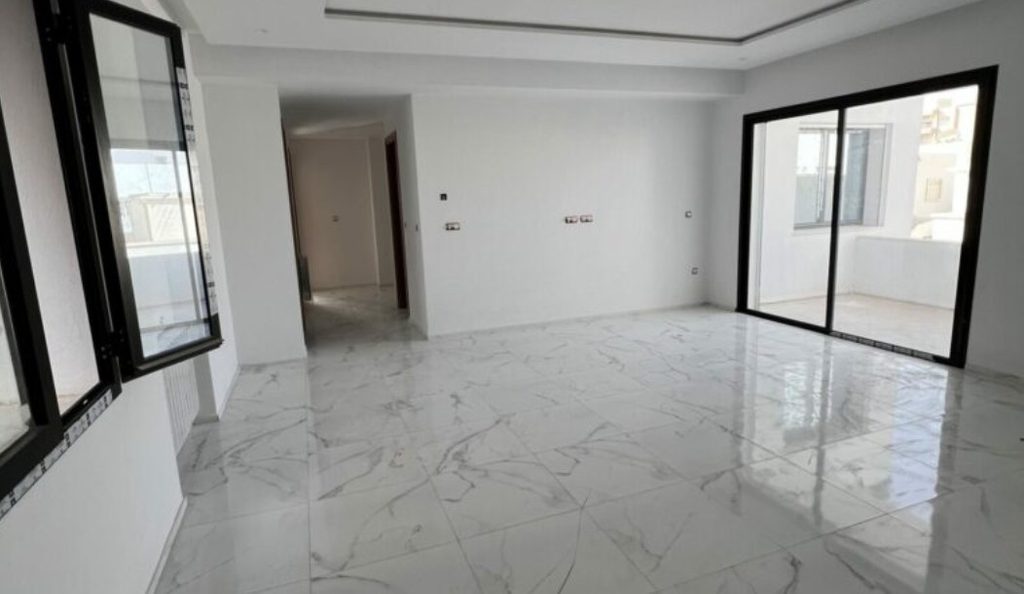 Salon vide au sol en marbre d'un appartement à vendre à Sfax, à comparer selon la surface et le prix au m²