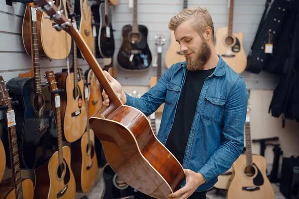 Acheteur vérifiant une guitare d’occasion en Tunisie avant achat