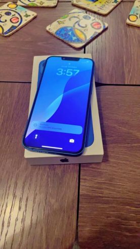 iPhone-13-bleu-pose-sur-une-table-avec-son-ecran-allume