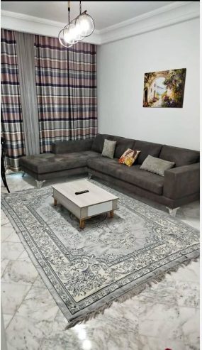 Salon-lumineux-avec-balcon-et-grande-baie-vitree-a-Ennasr
