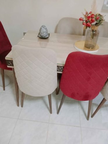 table-manger-verre-bois-chaises-beige-rouge