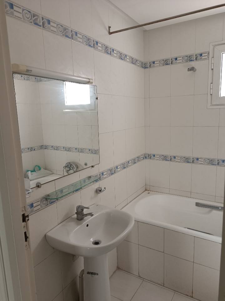salle-de-bain-appartement-s1-location-ennasr-1-baignoire-carrelage-blanc