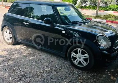 Mini Cooper 1.6 HDi noire d’occasion stationnée à Tunis vue de côté