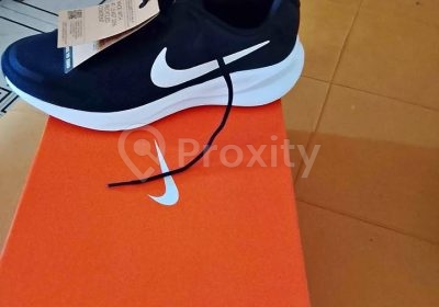 Basket Nike Revolution 7 noire pointure 44 neuve posée sur sa boîte orange, vue de profil